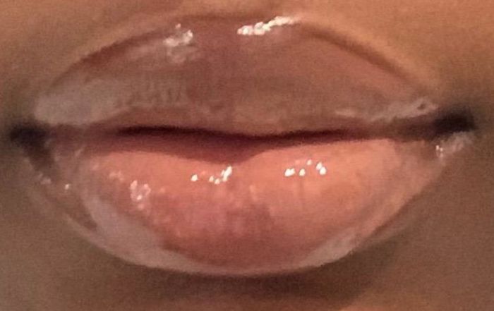 A close-up of the same reviewer with glossy lips, showcasing a full application of shiny lip gloss paired with the lip liner.