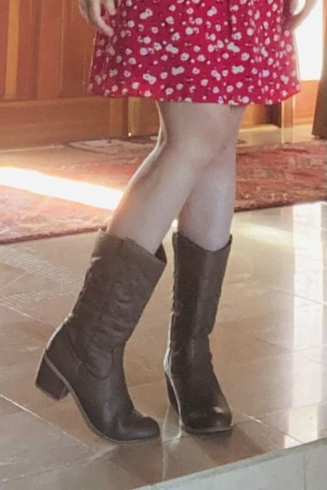 A reviewer pairing brown cowboy boots with a red dress