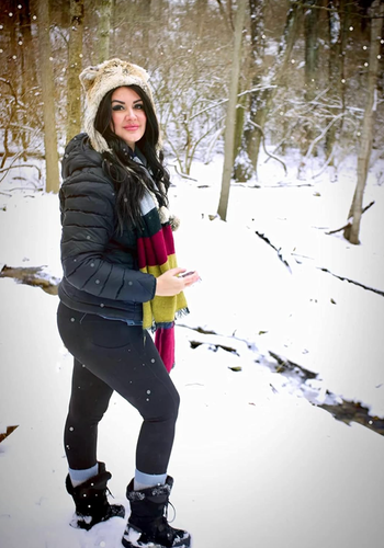 Reviewer trekking through the snow in black leggings