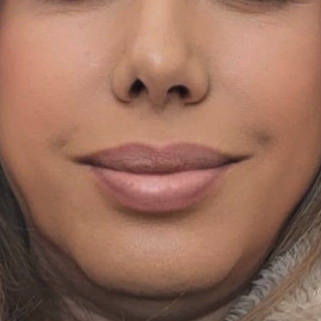 A close-up of a reviewer’s smile, showcasing her nude lips, along with part of her nose and chin.