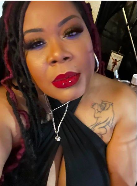 A reviewer sporting bold red lipstick paired with striking blue eye makeup.