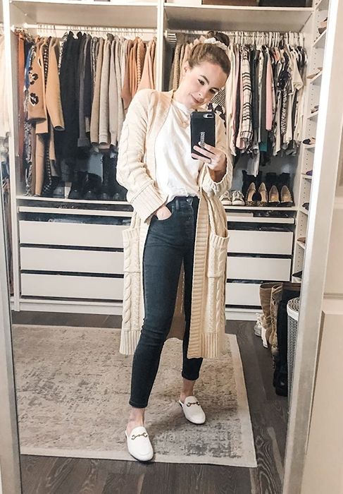 A reviewer wearing the loafer mules in white.