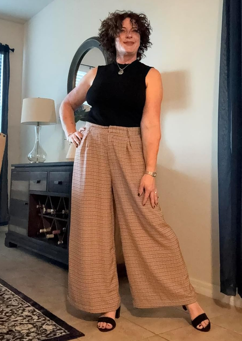 Reviewer wearing wide-leg trousers and a black top.