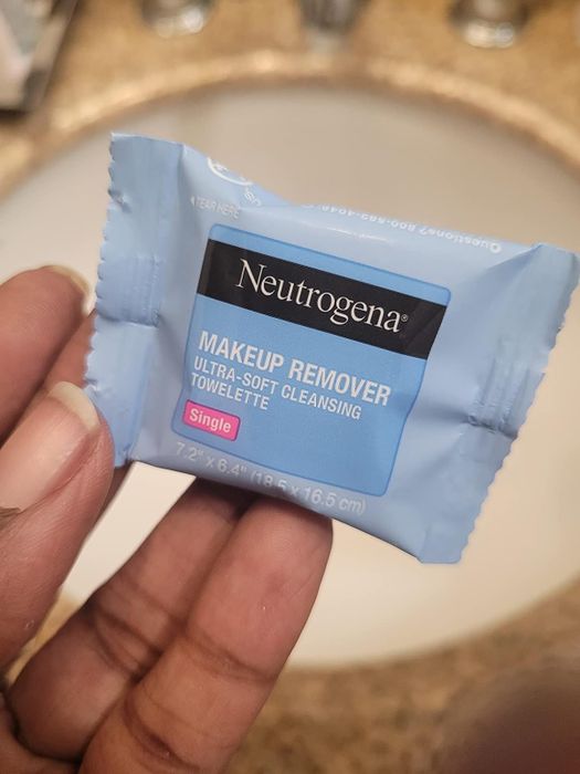 image of a reviewer holding an individually wrapped face wipe