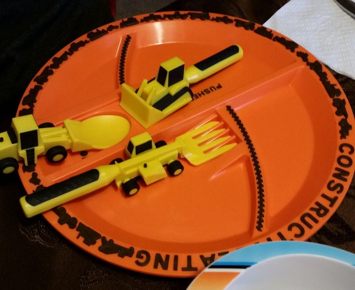 A reviewer photo featuring an orange plate with sections for utensils shaped like construction vehicles