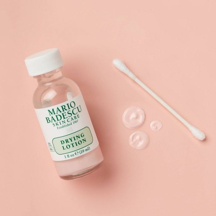 A bottle of drying lotion and a Q-tip