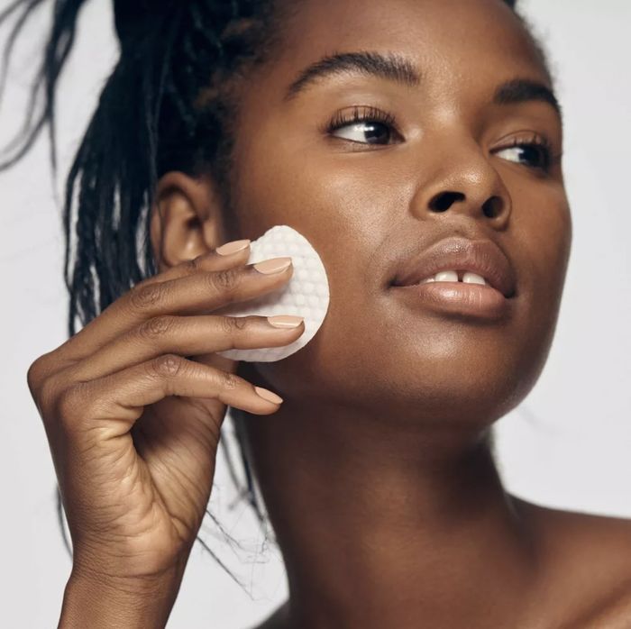 A person using a glycolic pad on their face