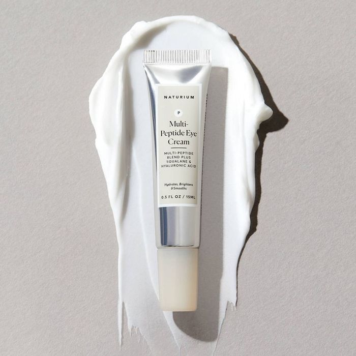 A tube of peptide eye cream resting beside it