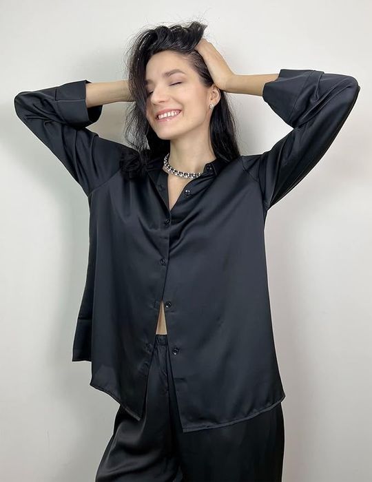 Model striking a pose in a sleek black outfit.