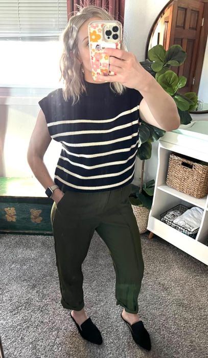 Person wearing a striped top, green pants, and black shoes