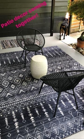 A blue Moroccan-style rug beautifully placed beneath patio furniture, adding a pop of color to the space