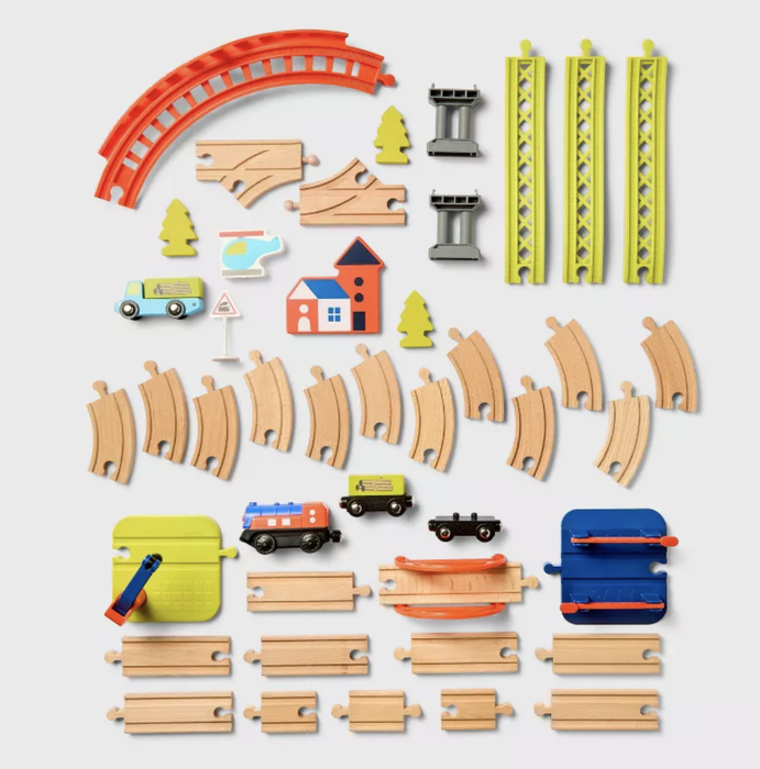 A toy train set featuring wooden tracks, bridge pieces, vehicles, trees, and buildings. All pieces are neatly arranged for easy setup and playtime fun.