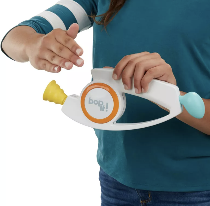 Hands actively engaging with a Bop It! toy, highlighting its interactive features for maximum fun.
