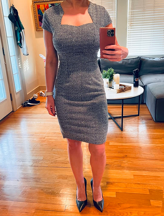 Person in a fitted knee-length dress and black pumps
