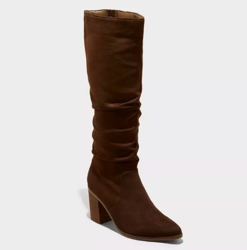 A knee-high brown suede boot featuring a mid-height heel and a relaxed, slouchy design