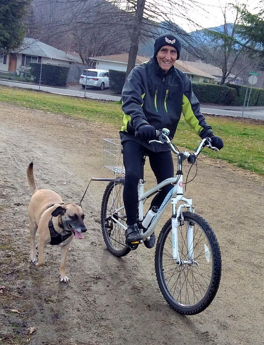 A reviewer cycling with the dog leash attachment fixed to their bike.