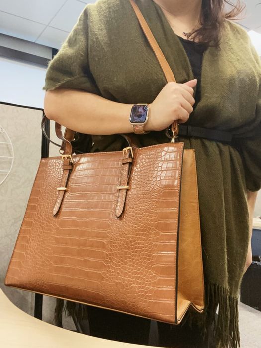 Person holding a brown tote bag