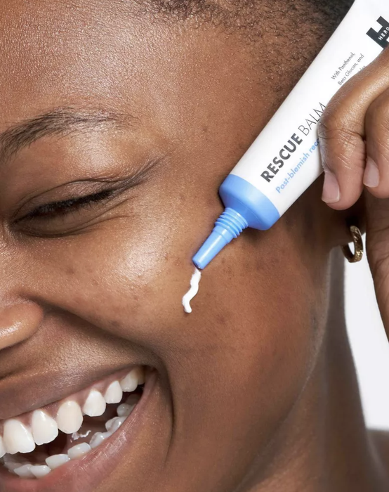 A model applying Hero Cosmetics rescue balm to their face