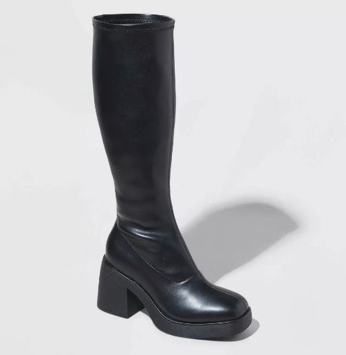 Knee-high black leather boots with a chunky heel, designed for bold, confident wear