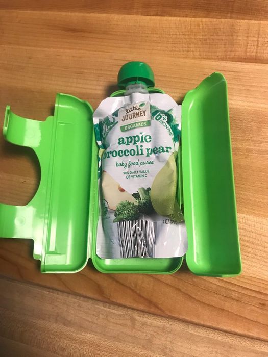 Little Journey Organics baby food puree in apple, broccoli, and pear flavor, packaged in a green container.