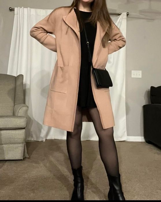 Reviewer wearing a tan long cardigan jacket