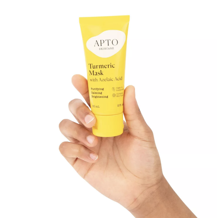 A person holding a tube of face mask