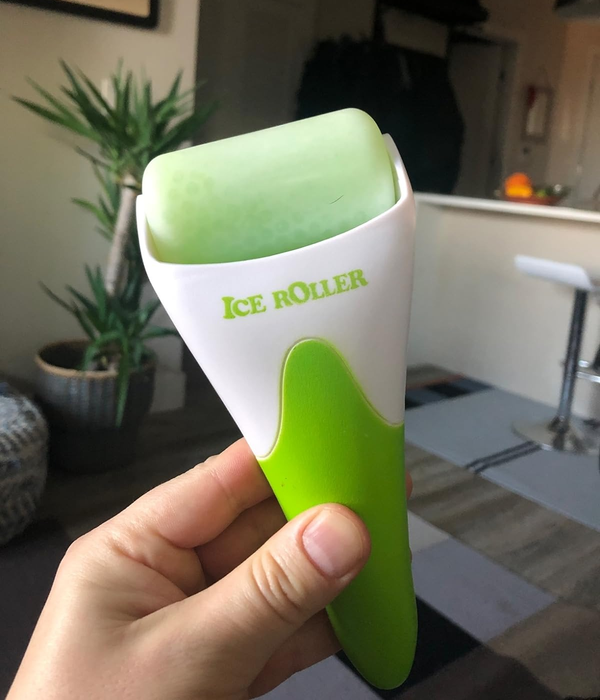 image of a reviewer holding the green ice roller in their hand