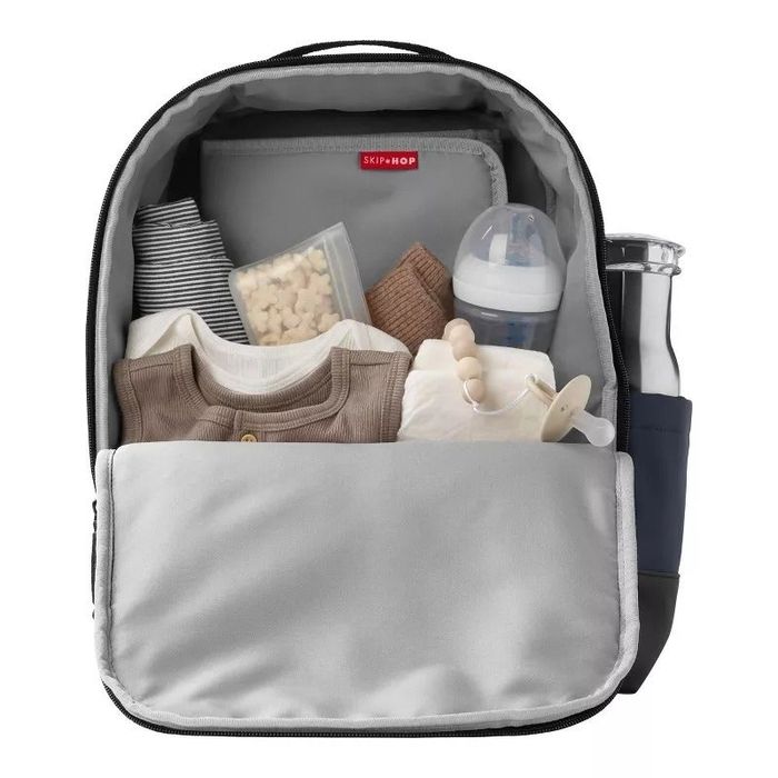 An open diaper bag filled with baby essentials like clothes, a bottle, and snacks, ready for the day ahead.