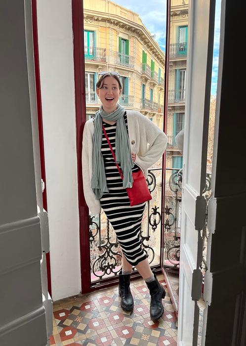 A reviewer styling the light blue scarf with a striped dress and a white cardigan