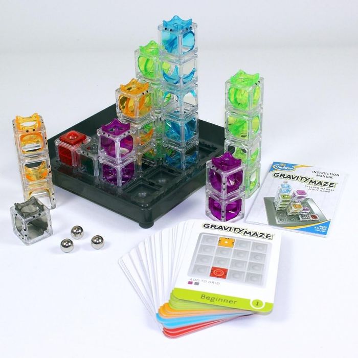 Gravity Maze game set with colorful towers, marbles, challenge cards, and a booklet of instructions