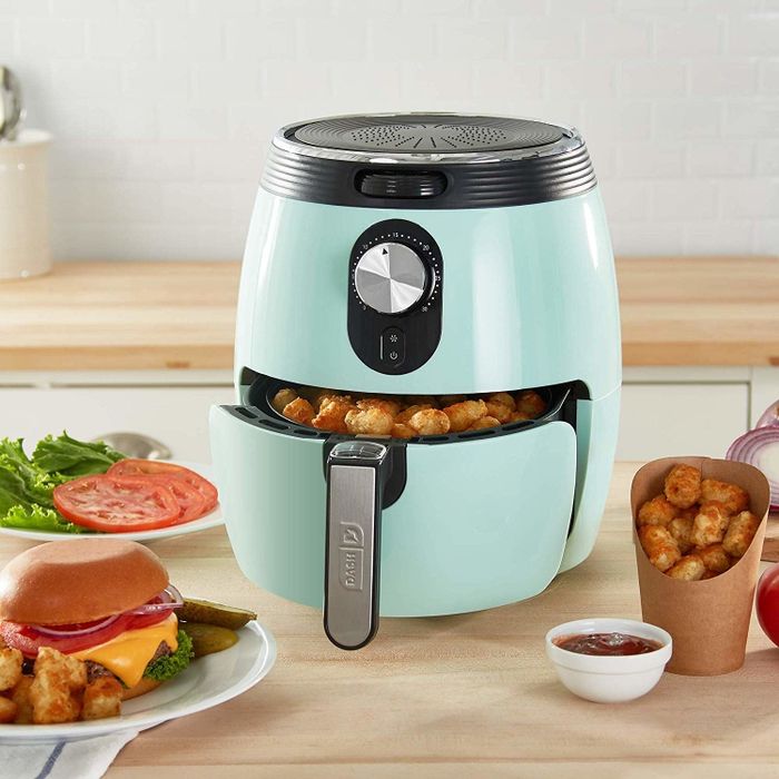 The light blue air fryer with a basket full of tater tots