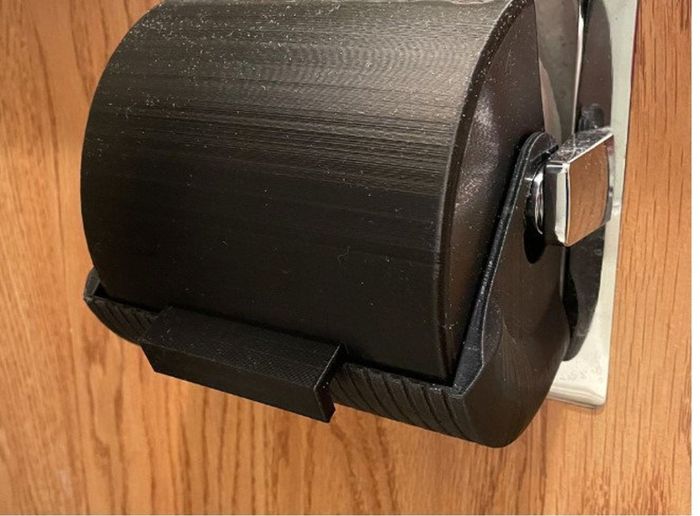 The black protector fully closed around the toilet paper roll.