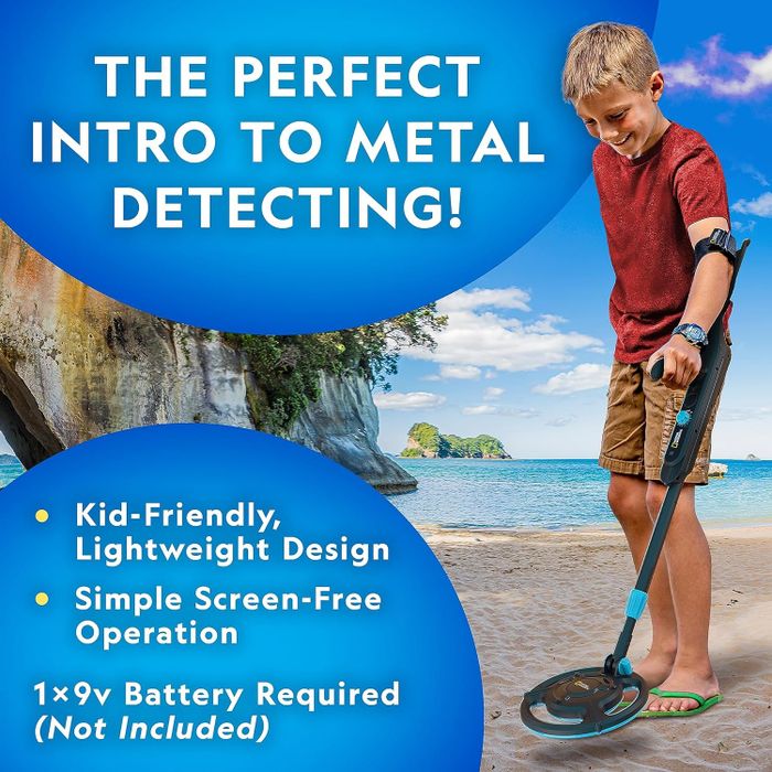 A young child using a metal detector on the beach, excited to find something