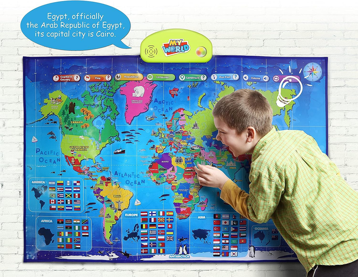 A child explores a large, colorful world map displayed on the wall