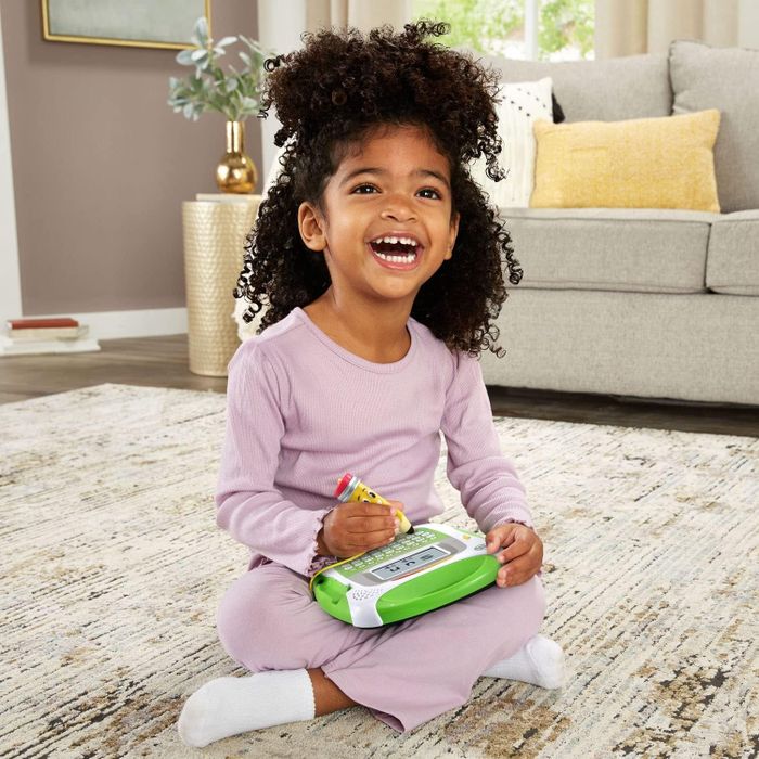 A child beaming, holding a children’s tablet with excitement