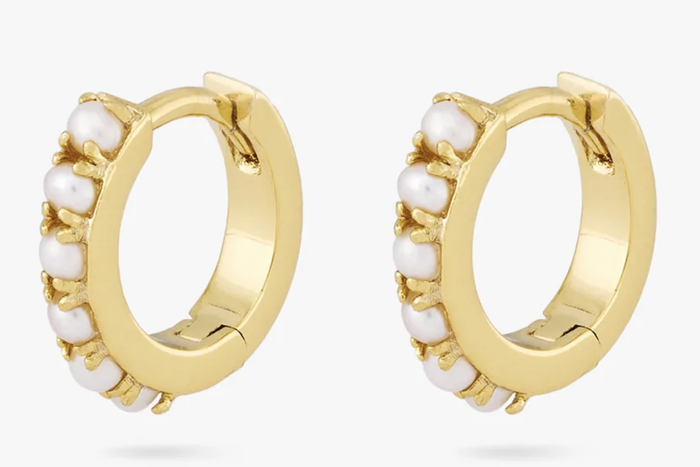 The huggie earrings featuring six pearls lined up along the front of each hoop