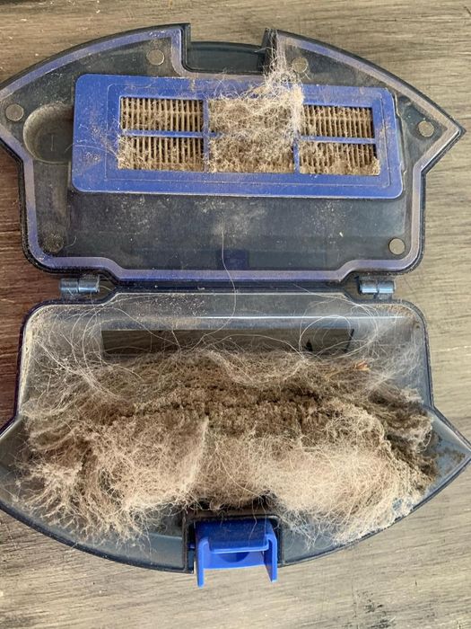 Another reviewer revealing the inside of their robot vacuum, filled with dust and debris.