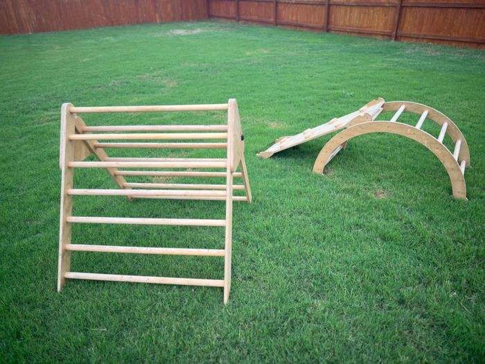 Wooden climbing structures, featuring both a triangular and an arched ladder for playful exploration