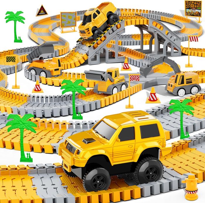 A construction site-themed racing track set featuring multiple yellow toy trucks and vehicles navigating a detailed track layout with ramps, bridges, and road signs