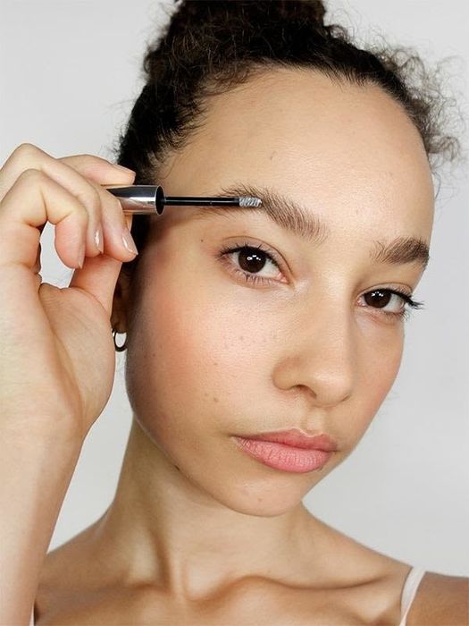 A model brushing the Boy Brow on their eyebrows