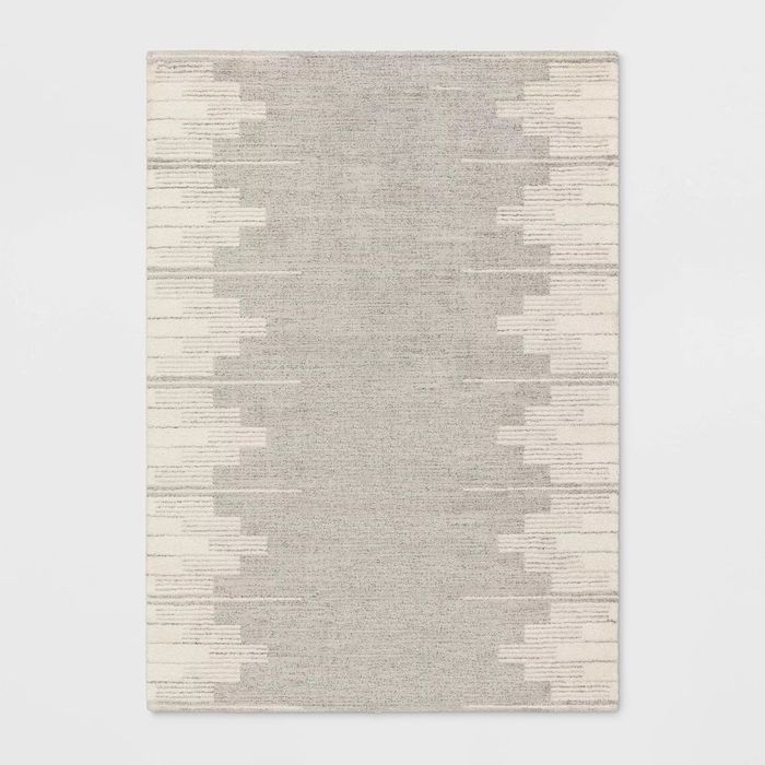 Gray area rug featuring an abstract white pattern.