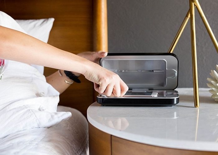 The sanitizer with a phone inside and a space for a charging cord