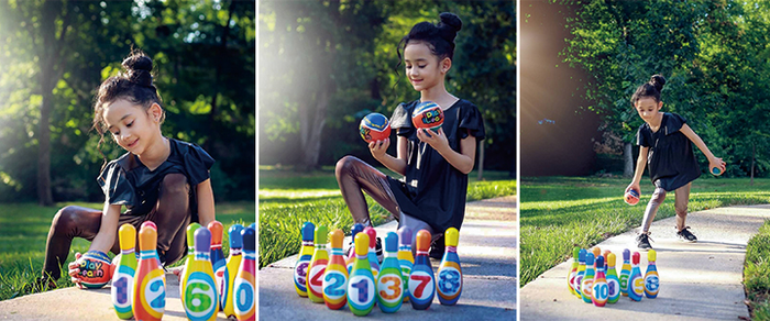 Child playing with a colorful, numbered backyard bowling set, complete with balls and pins