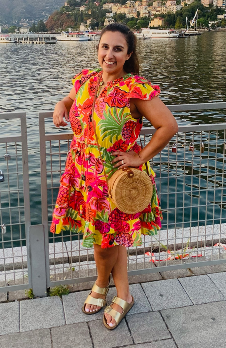 The writer of the article wearing gold Birkenstocks paired with a colorful dress on vacation