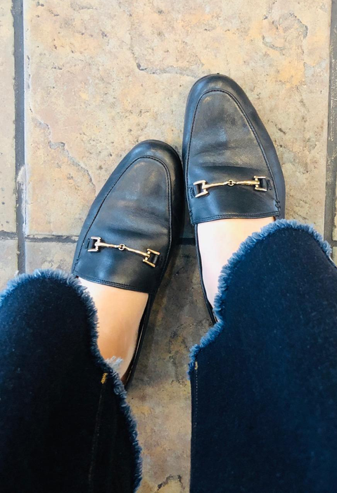 A reviewer showcasing the black loafers