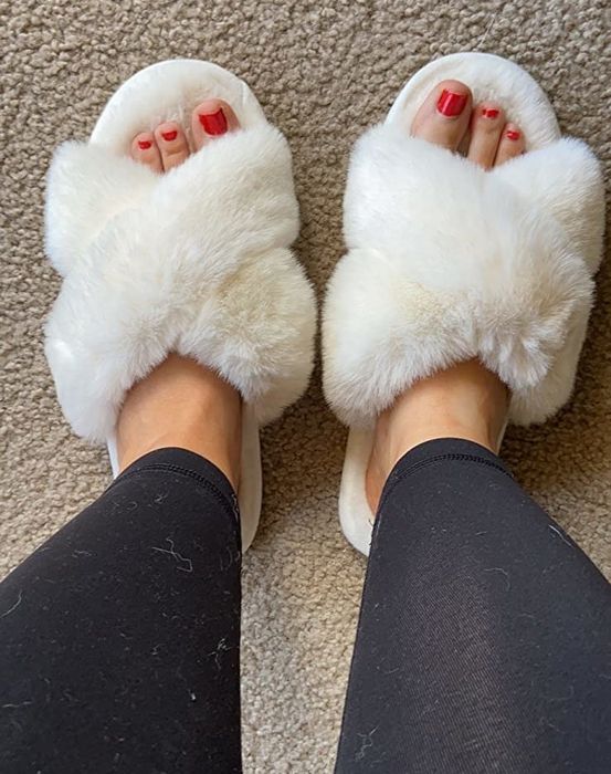 Reviewer wearing the white fuzzy slippers