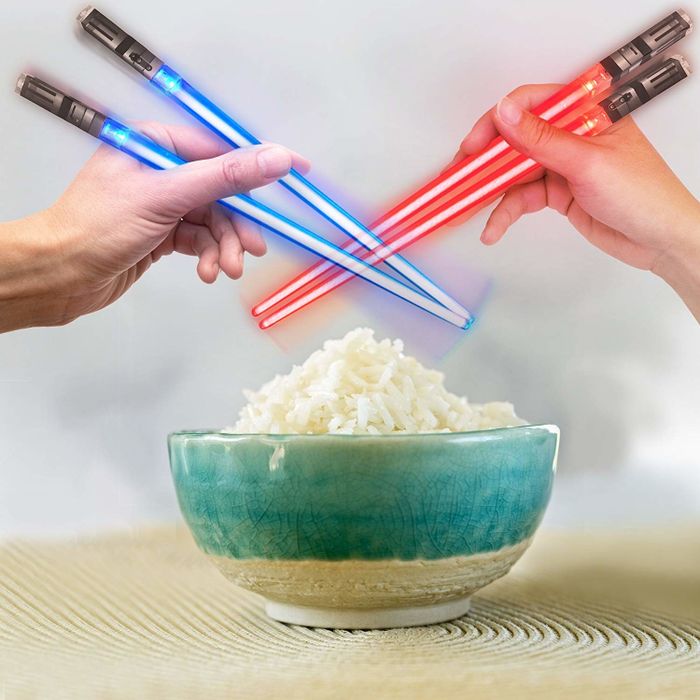 Two glowing lightsaber chopsticks dueling over a bowl of rice.