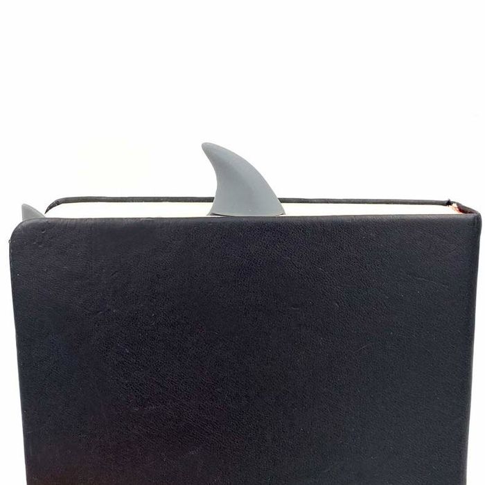 a shark fin popping out from the top of a book