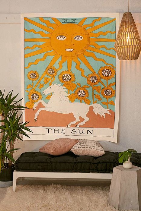 tapestry featuring the sun, a horse, the moon, and flowers
