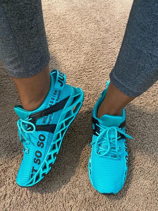 A reviewer wearing the sneakers in a vibrant bright blue
